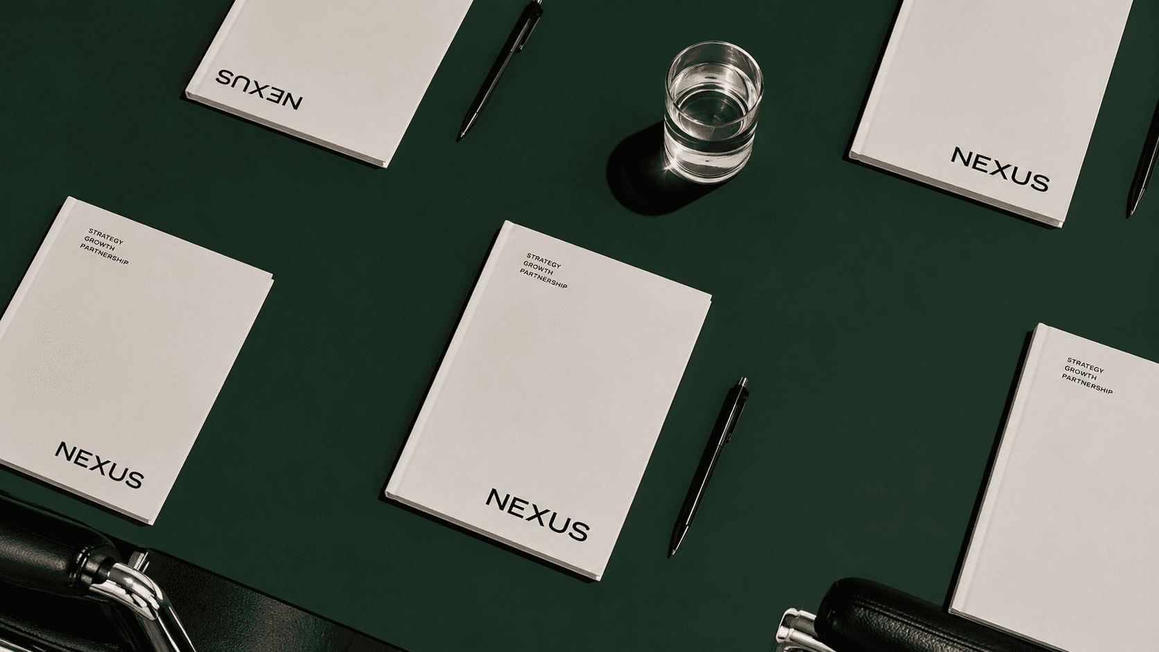 Nexus corporate notebooks on a deep green desk